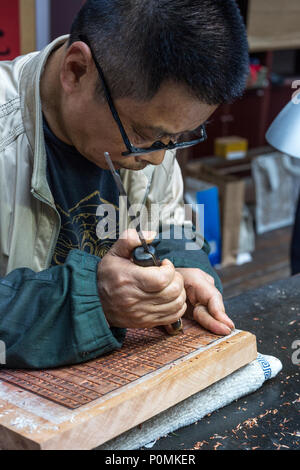 Yangzhou, Jiangsu, China. China Block Printing Museum. Kalligraph Schnitzen chinesische Zeichen in Holz blockieren. Stockfoto