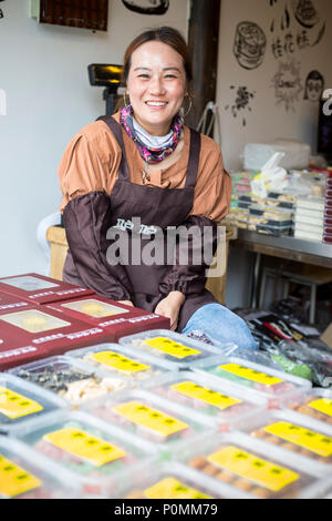 Yangzhou, Jiangsu, China. Junge Frau mit Snacks in Dong Guan Straße. Stockfoto