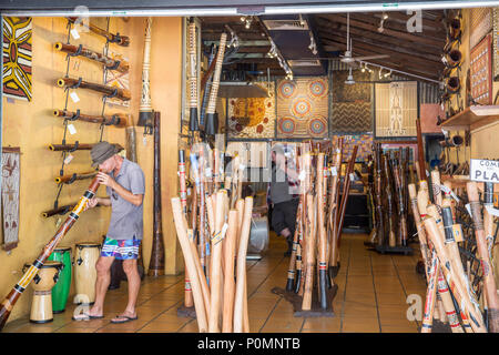 Shop im Stadtzentrum von Cairns verkaufen Didgeridoo Blasinstrumente und ein Mann spielt ein Didgeridoo, Cairns, Queensland, Australien Stockfoto