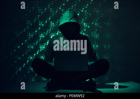 Getonten Bild der Silhouette des Hackers in mit Laptop Hoodie Stockfoto