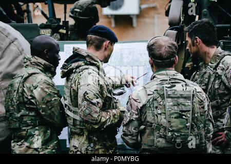 Eine britische Armee Soldat mit 1 Queen's Dragoon Guards, plant eine Aufklärung Übung während Sabre Streik 18 mit Battle Group Polen Bemowo Piskie, Polen, 2. Juni 2018. Sabre Streik ist eine multinationale Übung derzeit in seinem achten Jahr. Die diesjährige Übung, die läuft von Juni 3-15, tests Verbündete und Partner aus 19 Ländern auf ihrer Fähigkeit, arbeiten zusammen, um die Aggression in der Region zu verhindern und die Fähigkeit der einzelnen Einheit ihre benannten Mission durchführen zu verbessern. (U.S. Armee Foto von SPC. Hubert D. Delany III) Stockfoto