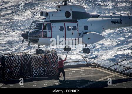 180603-N-OA 516-0058 5. US-Flotte BEREICH VON OPERATIONEN (Juni 3, 2018) ein Matrose auf dem Trockenen Cargo und Munition Ship USNS Amelia Earhart (T-AKE 6) Paletten zu einer SA-330 J Puma Hubschrauber während einer vertikalen Auffüllung am Meer verbindet, 3. Juni 2018. Iwo Jima in Mayport, Fla. homeported, ist auf die Bereitstellung zu den USA 5 Flotte Bereich für Maßnahmen zur Erhöhung der Sicherheit des Seeverkehrs Operationen Verbündeten und Partnern zu beruhigen, und der Freiheit der Schiffahrt und des freien Handels in der Region erhalten. (U.S. Marine Foto von Mass Communication Specialist 3. Klasse Kevin Leitner/Freigegeben) Stockfoto