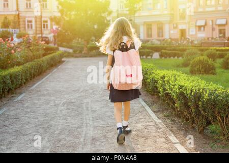 Ansicht der Rückseite des jungen Schülerin in Uniform mit Rucksack in die Schule zu gehen Stockfoto