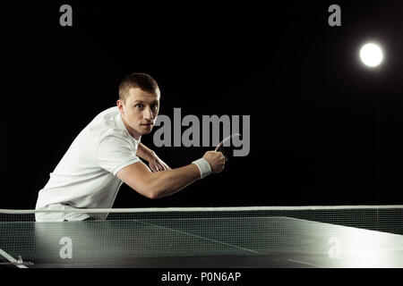 Porträt der jungen Tennisspieler spielen Tischtennis isoliert auf Schwarz Stockfoto