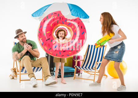 Familie von Touristen mit Flotation ring, Kamera und Wasserpistole auf Weiß, Travel Concept isoliert Stockfoto