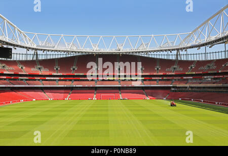 Ein Traktor trimmt das Gras auf dem Spielfeld im Londoner Emirates Stadium, das Heimstadion Erstligisten Arsenal. Stockfoto