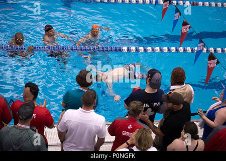 Team "SOCOM"-Veteran Kapitän James Howard konkurriert im 2018 DoD Krieger spiele Schwimmen Wettbewerb von Anhängern und Wettbewerber im Rennen in der Air Force Academy in Colorado Springs, Colo. Juni 8, 2018 umgeben. (DoD Foto von EJ Hersom) Stockfoto