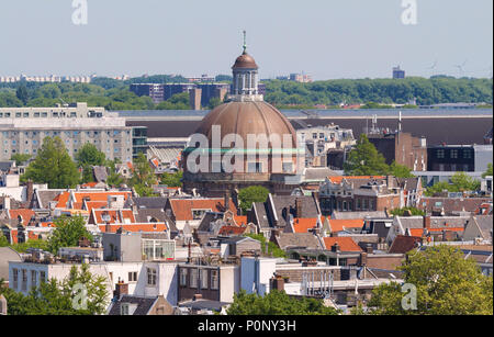 Runde Koepelkerk mit kupfernen Kuppel neben Singel Kanal. Dächer und Fassaden von Amsterdam. Blick auf die Stadt vom Glockenturm der Kirche Westerkerk, Holland, Niederlande. Stockfoto