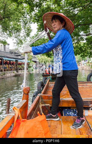 Suzhou, Jiangsu, China. Frau mittleren Alters Ruderboot für Besucher auf einem Kanal in Tongli antiken Stadt in der Nähe von Suzhou. Stockfoto