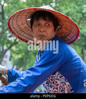 Suzhou, Jiangsu, China. Frau mittleren Alters Ruderboot für Besucher auf einem Kanal in Tongli antiken Stadt in der Nähe von Suzhou. Stockfoto