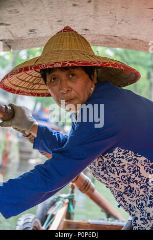 Suzhou, Jiangsu, China. Frau mittleren Alters Ruderboot für Besucher auf einem Kanal in Tongli antiken Stadt in der Nähe von Suzhou. Stockfoto