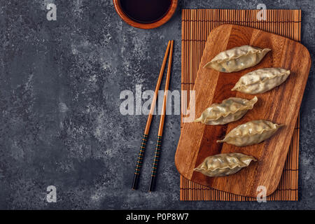 Frische Knödel auf einem dunklen Stein Hintergrund. Asiatische Küche, Ansicht von oben, kopieren. Stockfoto