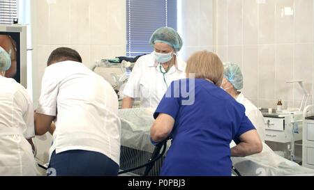 Gruppe von Ärzten und Krankenschwestern Blick auf den Monitor während der chirurgischen Operation Stockfoto