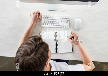 Ansicht von oben der Student Zeichnung Grafik im Notebook und das Arbeiten am Computer während der Hausaufgaben Stockfoto