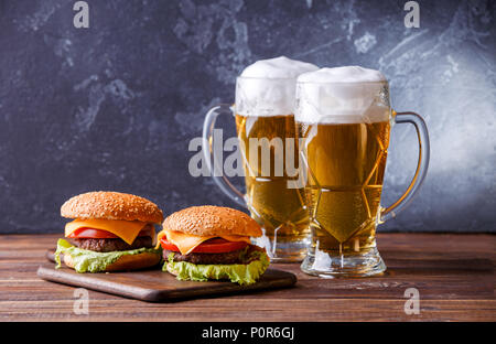 Foto von zwei Hamburger, Gläser mit Bier Stockfoto