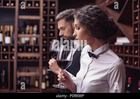 Zwei Sommeliers, männlichen und weiblichen Weinprobe Rotwein im Keller Stockfoto