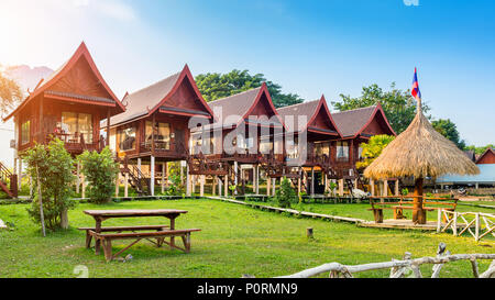 Dorf und Bungalows entlang dem Fluss Nam Song in Vang Vieng, Laos. Stockfoto