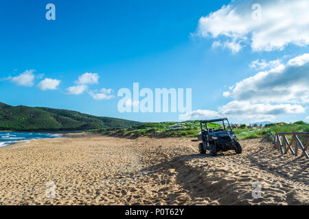 Schwarz quad auf dem sardischen Strand von Porto Ferro an einem bewölkten Morgen Sommer Stockfoto