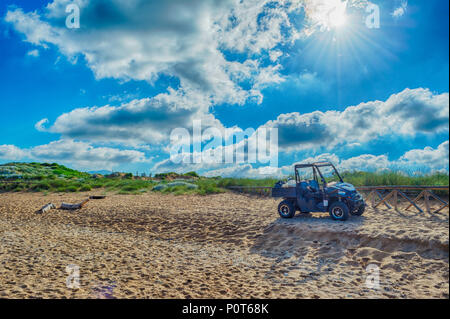 Schwarz quad auf dem sardischen Strand von Porto Ferro an einem bewölkten Morgen Sommer Stockfoto