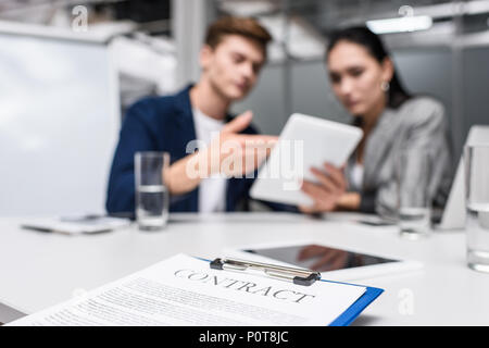 Vertrag über die Zwischenablage an Büro mit Managern auf Tablet auf Hintergrund verschwommen Stockfoto
