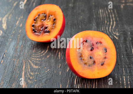 Zwei Hälften tamarillo Obst auf hölzernen Hintergrund close-up Stockfoto