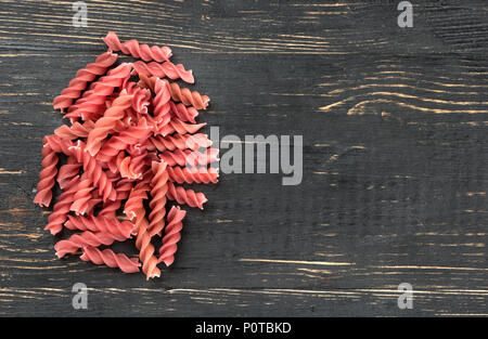 Kleine Strauß roter Pasta Fusilli auf leeren Holz- Hintergrund Stockfoto