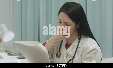 Weibliche Arzt Ernst beobachten, Prüfung der Ergebnisse ihrer Patienten zu diagnostizieren Stockfoto