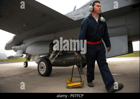 Airman 1st Class Darren Arellano, 52 Aircraft Maintenance Squadron assistant engagierte Crew Chief, zieht Unterlegkeile unter einer F-16 Fighting Falcon, bevor ein 14 vorne Starten in Spangdahlem Air Base, Deutschland, Mai 4., 2017. Stockfoto