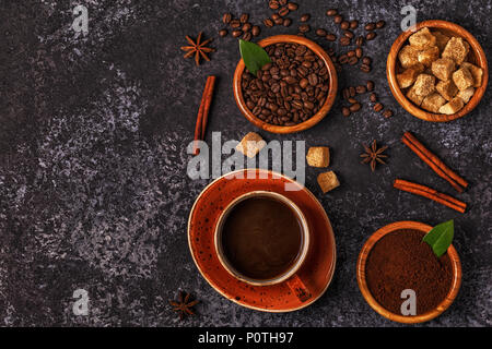 Tasse Kaffee, Bohnen, gemahlen Pulver und Zucker auf Stein Hintergrund. Stockfoto