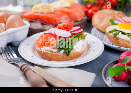 Brot mit Käse, Lachs und Spargel. Verschiedene gesunde Essen. Leckeres Frühstück für die Familie Stockfoto