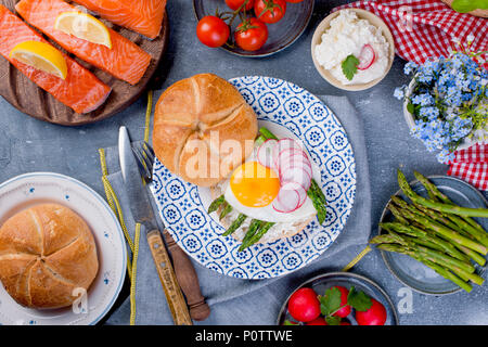 Brot mit Käse, Lachs und Spargel. Verschiedene gesunde Essen. Leckeres Frühstück für die Familie. Blick von oben. Niederländische Abendessen Stockfoto