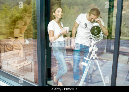 Paar mit Teleskop zu Hause Stockfoto