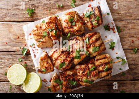 Afghanistan's Grill: gegrillte Hähnchenspieße Kebab e Murgh close-up auf Papier auf einem Tisch. horizontal oben Ansicht von oben Stockfoto