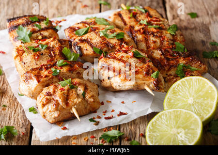 Afghanistan's Grill: gegrillte Hähnchenspieße Kebab e Murgh close-up auf Papier auf dem Tisch. Horizontale Stockfoto