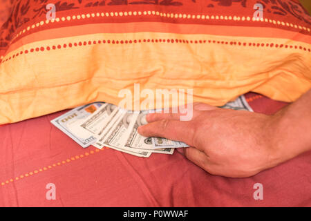 Hände mit Geld verstecken unter der Matratze Stockfotografie - Alamy