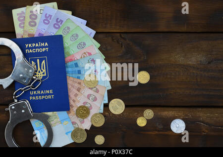Ein Foto von einem ukrainischen ausländischer Reisepass, eine bestimmte Menge von ukrainischen Geld und Polizei Handschellen. Das Konzept der Verhaftung von Ukrainischen illegalen imm Stockfoto