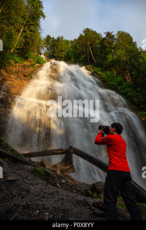 Mann genießen der schönen Wasserfall. In Bridal Veil Falls Provincial Park in der Nähe von Chilliwack, östlich von Vancouver, British Columbia, Kanada. Stockfoto