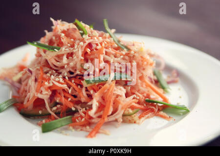 Vegan Salat mit Karotten und Rettich. Asiatische Küche. Gesunde vegetarische Vorspeise auf die runde Platte. Beilage. Einfach wenig Kalorien Mittagessen. Stockfoto