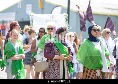 Cardiff, Wales, UK, 10. Juni 2018. Frauen und Mädchen außerhalb Cardiff City Stadion zu Beginn des März für Prozessionen, eine Masse Artwork zu 100 Jahre Frauen stimmen Feiern, über dem britischen Städte von Cardiff, Belfast, Edinburgh und London koordiniert. Stockfoto