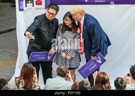 Singapur. 10. Juni 2018. Hong Kong-based Kim Jung-Un Imitator Howard X, und Trump Doppelgänger und Dennis Alan gesehen, Fotos mit der Einheimischen genommen wie die echten US-Präsident Donald Trump und dem nordkoreanischen Führer Kim Jung Un in Singapur für ihre historischen Gipfel berührt. Credit: SOPA Images Limited/Alamy leben Nachrichten Stockfoto