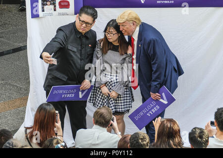 Singapur, Singapur. 10 Juni, 2018. Hong Kong-based Kim Jung-Un Imitator Howard X, und Trump Doppelgänger und Dennis Alan gesehen, Fotos mit der Einheimischen genommen wie die echten US-Präsident Donald Trump und dem nordkoreanischen Führer Kim Jung Un in Singapur für ihre historischen Gipfel berührt. Credit: Sion Ang/SOPA Images/ZUMA Draht/Alamy leben Nachrichten Stockfoto