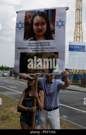 Mainz, Deutschland. 10. Juni 2018. Rechtsextreme Demonstranten halten Sie ein Plakat mit den Bildern von Susanna F. und Angela Merkel, die usanna F. - Merkel, ihre Politik me' getötet liest. Rechtsextreme Demonstranten der Beweg war Deutschland (nach Deutschland) Bewegung halten Sie Ihre regelmäßigen 14-tägig regierungsfeindlichen Kundgebung in Mainz. Diese Wochen Protest unter dem Vorwand, eine Mahnwache für den Jugendlichen Susanna F, der angeblich von einem Flüchtling in Wiesbaden getötet wurde gehalten wurde, die Rallye wurde von mehreren Anti-government Referenten, die forderte, dass die Regierung zum Rücktritt gerichtet. Quelle: Michael Debets/Alamy leben Nachrichten Stockfoto