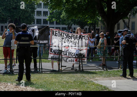 Mainz, Deutschland. 10. Juni 2018. Gegen Demonstranten halten ein Banner mit der Aufschrift 'Stop Rechtspopulismus - Kampf dem Rassismus". Rechtsextreme Demonstranten der Beweg war Deutschland (nach Deutschland) Bewegung halten Sie Ihre regelmäßigen 14-tägig regierungsfeindlichen Kundgebung in Mainz. Diese Wochen Protest unter dem Vorwand, eine Mahnwache für den Jugendlichen Susanna F, der angeblich von einem Flüchtling in Wiesbaden getötet wurde gehalten wurde, die Rallye wurde von mehreren Anti-government Referenten, die forderte, dass die Regierung zum Rücktritt gerichtet. Quelle: Michael Debets/Alamy leben Nachrichten Stockfoto