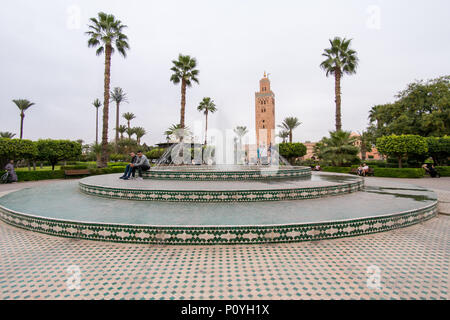 Marrakesch, Marokko - November 08, 2017: Blick auf die Koutoubia Moschee in Marrakesch von Lalla Hasna Park mit Brunnen und Palmen im Vordergrund. Stockfoto