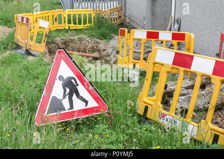 Männer an der Arbeit am Straßenrand Werke Warnschild mit Ausgrabungen in den Hintergrund. Konzept Straßenarbeiten, Männer an der Arbeit Piktogramm, öffentliche Warnzeichen. Stockfoto