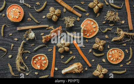 Getrocknete Kräuter und Ginseng, Close-up der thailändischen Kräutern und Ginseng auf Holzboden. Scheiben trocknet Root für ein Kraut Saft auf der dunklen Tisch machen. Stockfoto