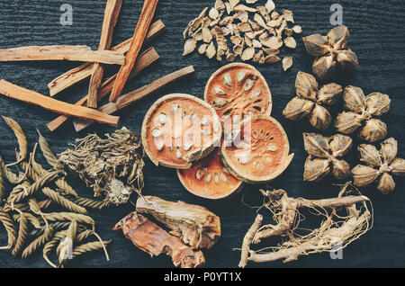 Getrocknete Kräuter und Ginseng, Close-up der thailändischen Kräutern und Ginseng auf Holzboden. Scheiben trocknet Root für ein Kraut Saft auf der dunklen Tisch machen. Stockfoto