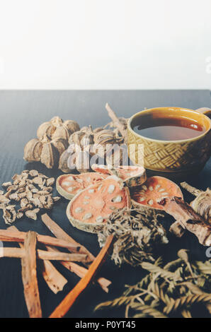 Getrocknete Kräuter und Ginseng, Close-up der thailändischen Kräutern und Ginseng auf Holzboden. Scheiben trocknet Root für ein Kraut Saft auf der dunklen Tisch machen. Stockfoto