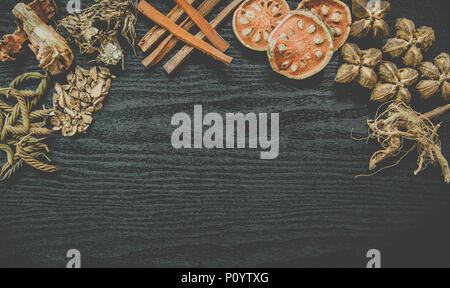 Getrocknete Kräuter und Ginseng, Close-up der thailändischen Kräutern und Ginseng auf Holzboden. Scheiben trocknet Root für ein Kraut Saft auf der dunklen Tisch machen. Stockfoto