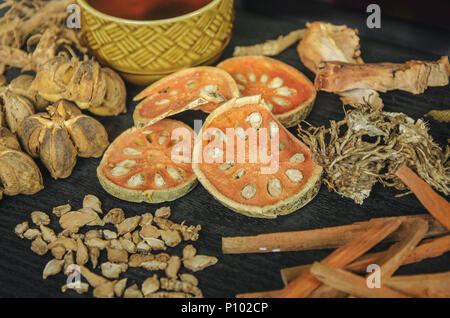 Getrocknete Kräuter und Ginseng, Close-up der thailändischen Kräutern und Ginseng auf Holzboden. Scheiben trocknet Root für ein Kraut Saft auf der dunklen Tisch machen. Stockfoto